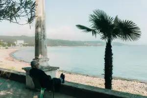 man sitting in a chair with his feet up overlooking the beach and ocean.