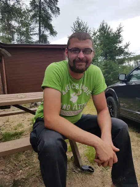 Me sitting on a bench with a cottage in the background.