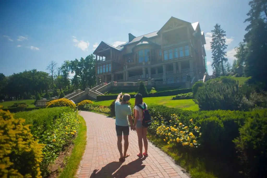 couple standing in front of a large house