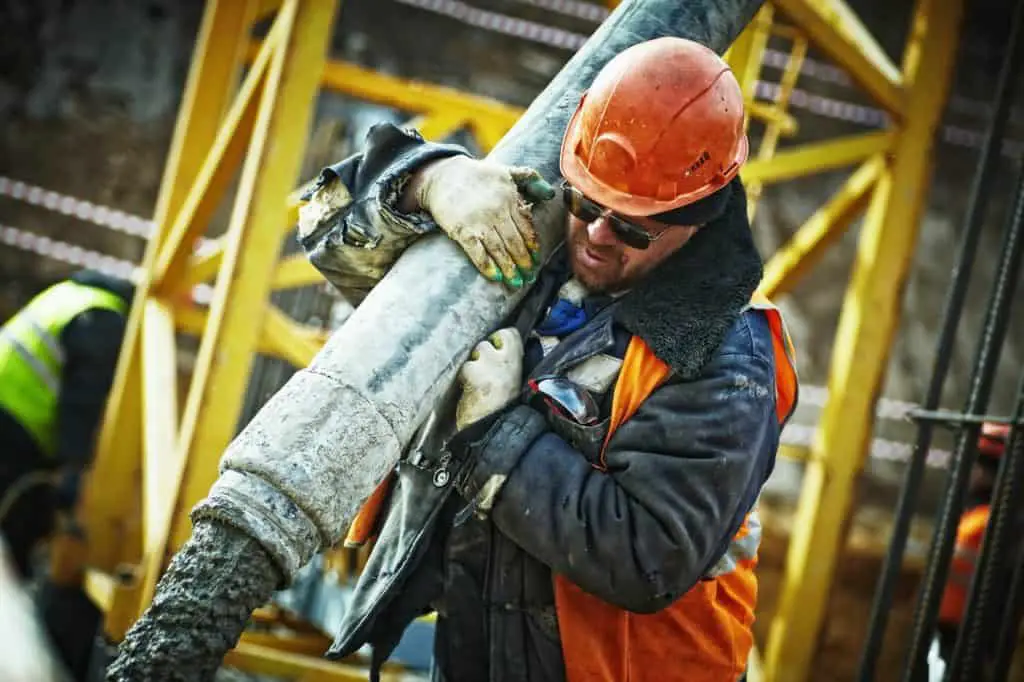 construction worker holding a grey pipe