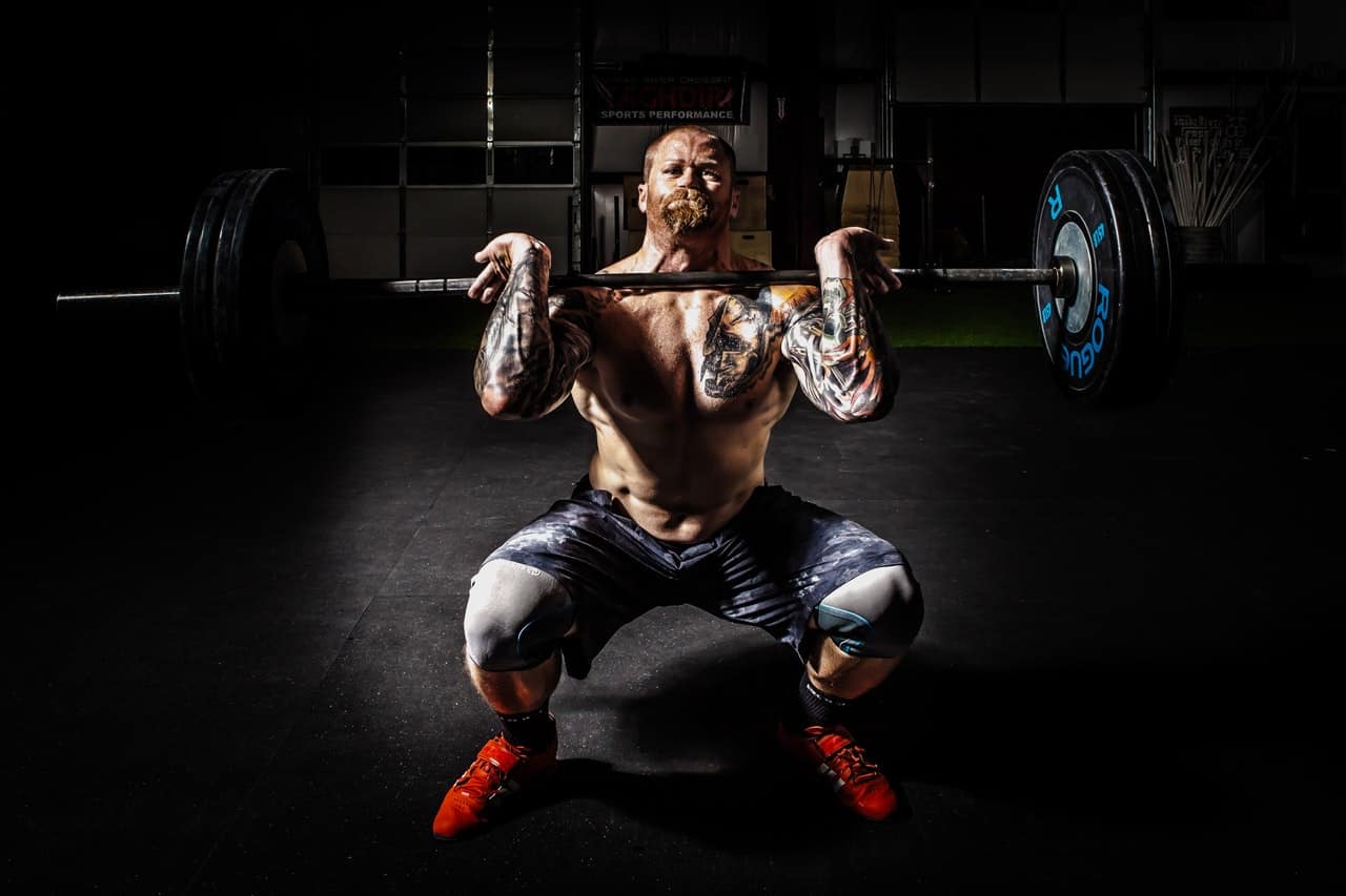 man front deadlifting a barbell