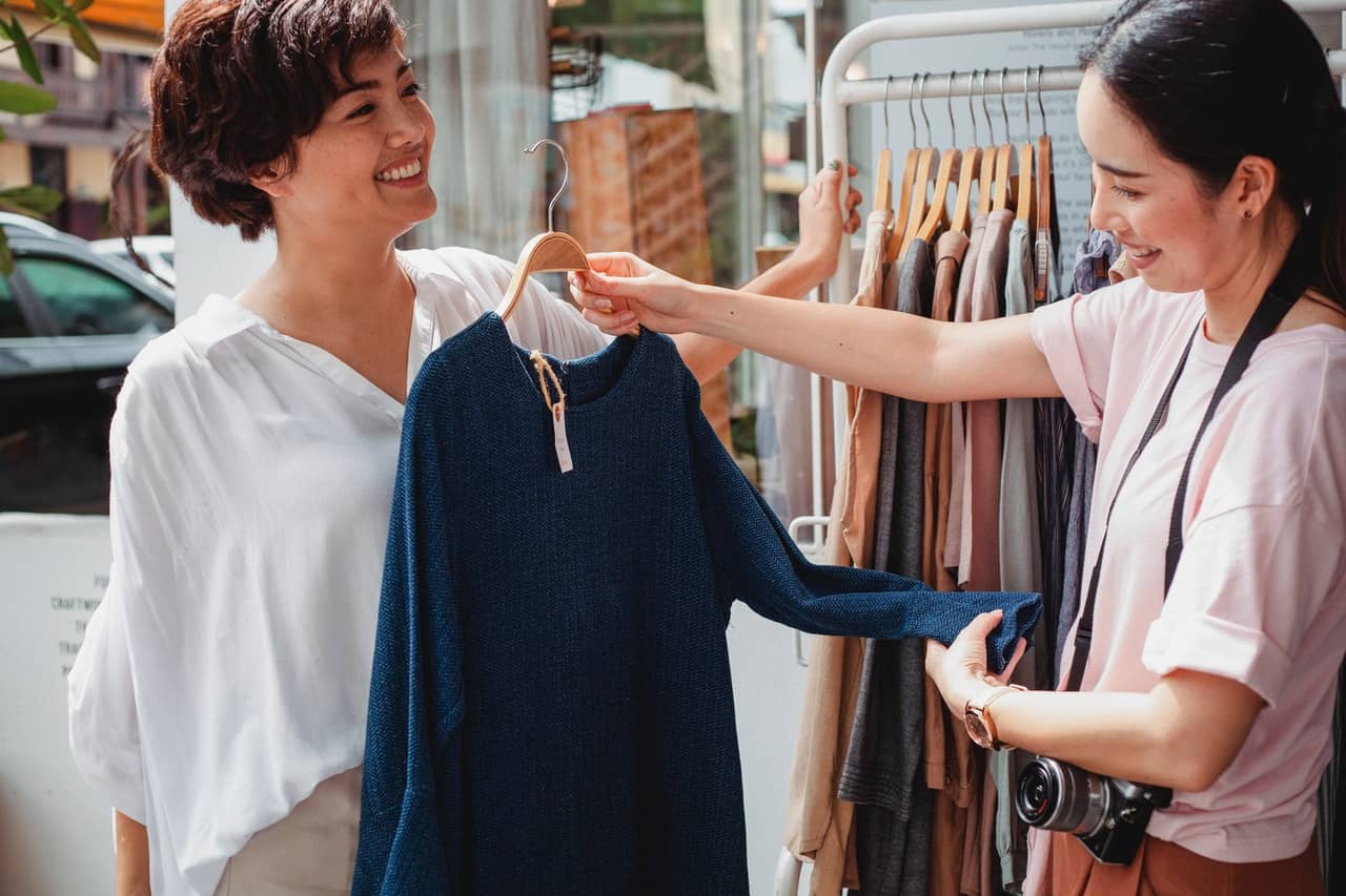 two girls shopping together to buy clothes