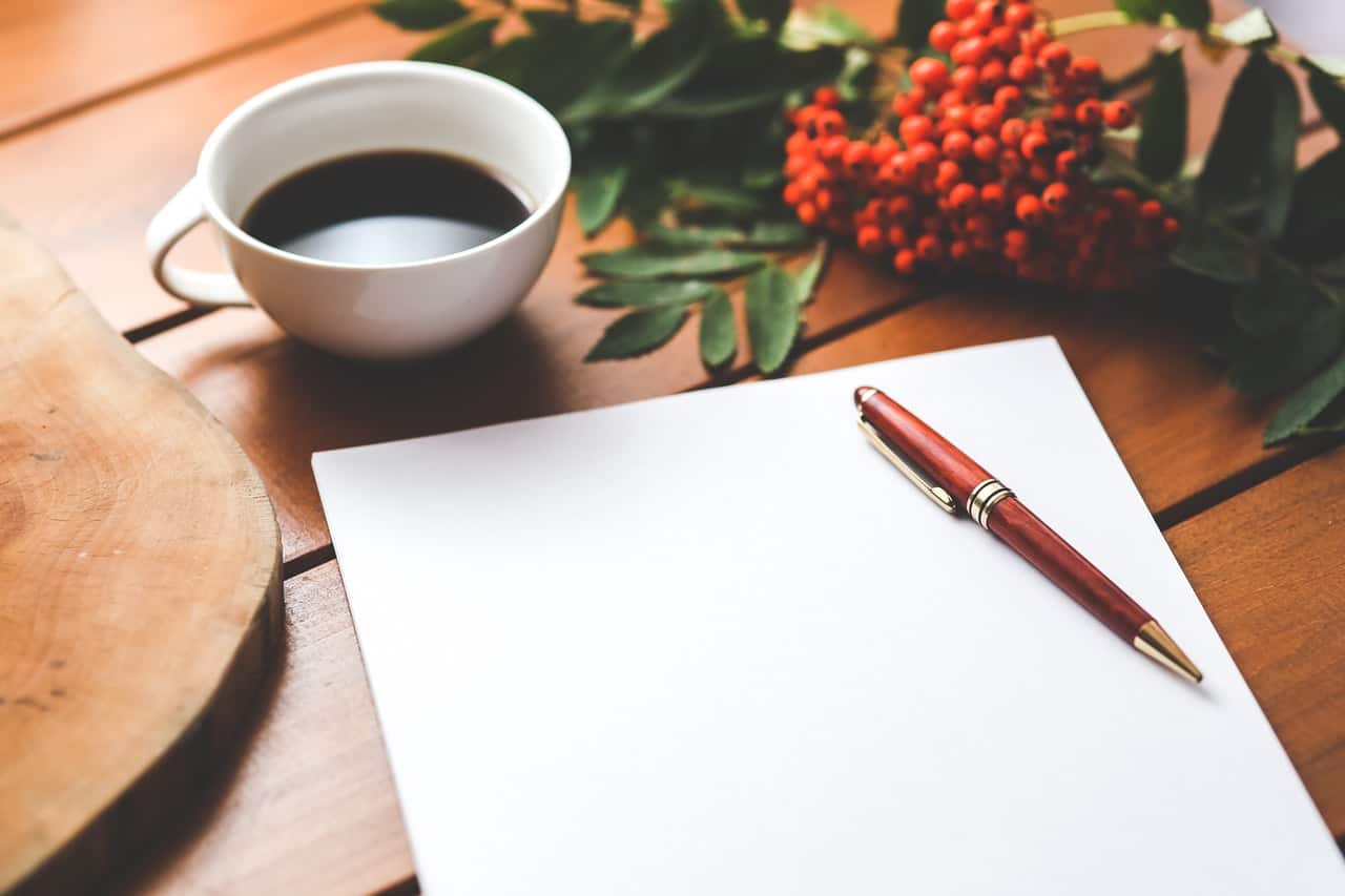 a desk set up to start writing with a tea