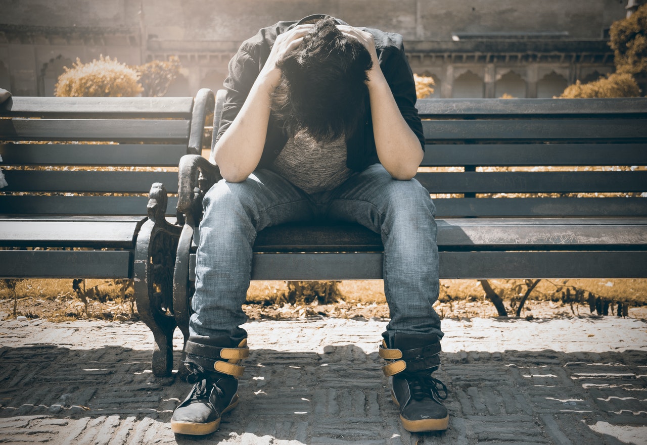 man sitting on a bench looking worried